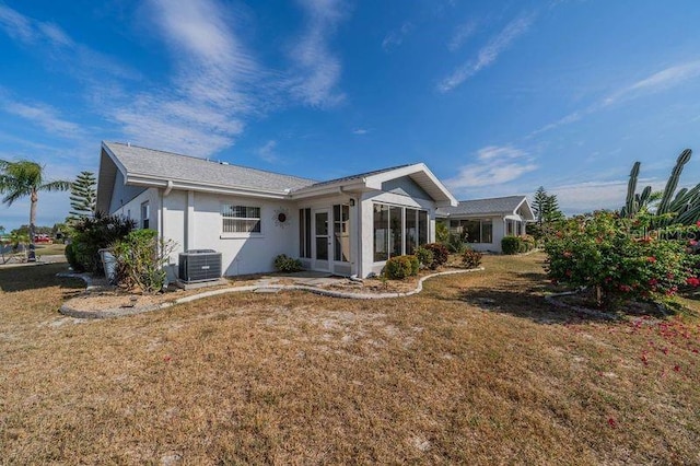 rear view of house with a yard, cooling unit, and a sunroom