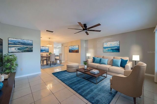 living room featuring ceiling fan with notable chandelier and light tile patterned flooring