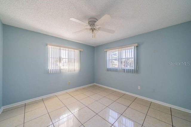 tiled spare room with a textured ceiling and ceiling fan