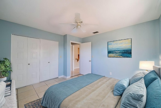 bedroom featuring ceiling fan, light tile patterned floors, and a closet