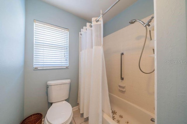 bathroom with curtained shower, tile patterned flooring, and toilet