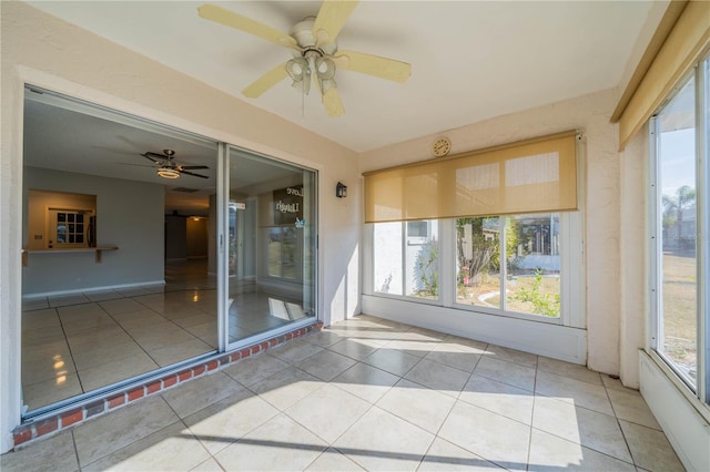 unfurnished sunroom featuring ceiling fan