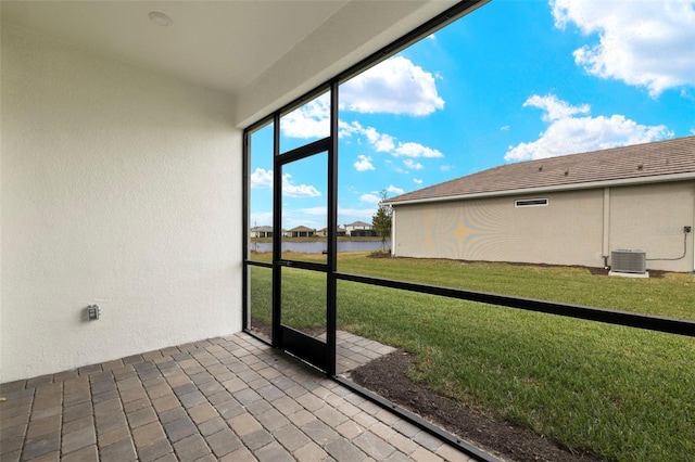 unfurnished sunroom featuring a water view