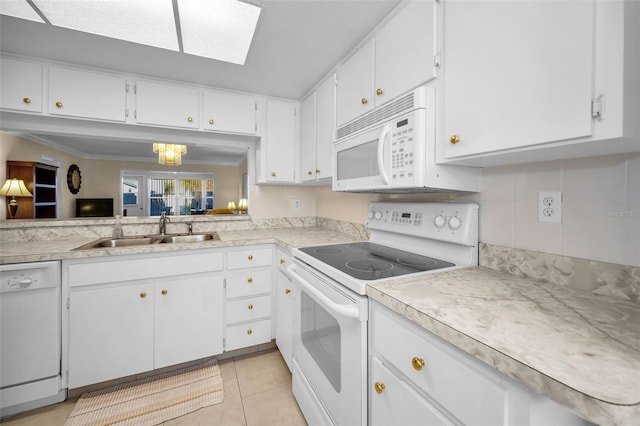 kitchen featuring white appliances, sink, a notable chandelier, white cabinetry, and light tile patterned flooring