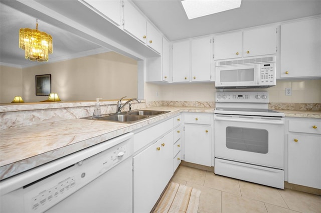 kitchen featuring white appliances, sink, hanging light fixtures, light tile patterned flooring, and white cabinetry