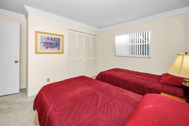 bedroom with a textured ceiling, light colored carpet, a closet, and crown molding