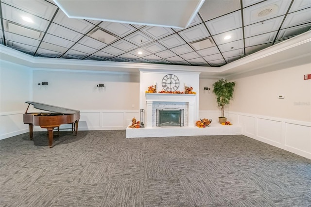 living room with a stone fireplace and crown molding