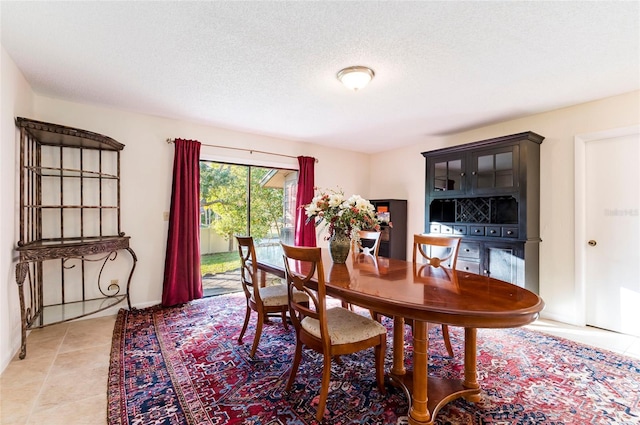 tiled dining area featuring a textured ceiling