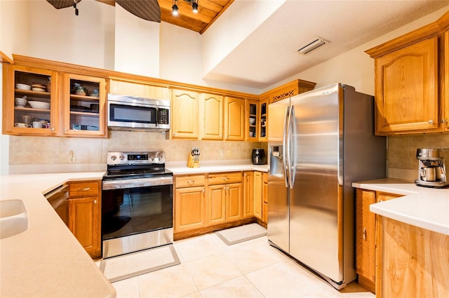 kitchen with sink, decorative backsplash, appliances with stainless steel finishes, light tile patterned flooring, and wood ceiling