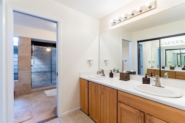 bathroom featuring vanity, a textured ceiling, and tiled shower