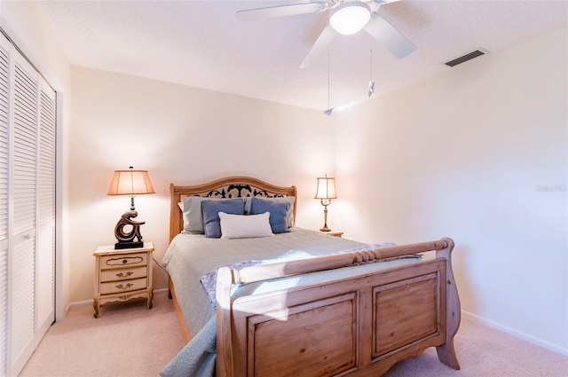 carpeted bedroom featuring ceiling fan and a closet