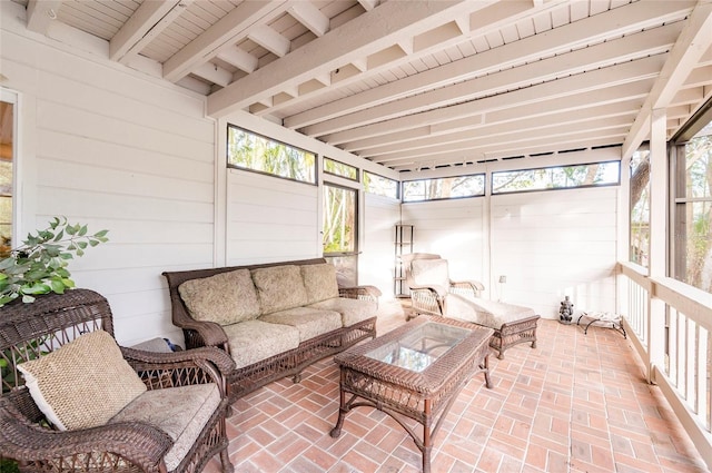 sunroom featuring beam ceiling