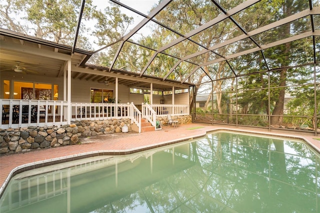 view of swimming pool featuring a patio, ceiling fan, and a lanai