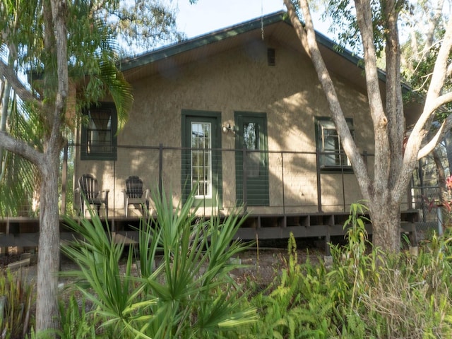 back of property featuring stucco siding