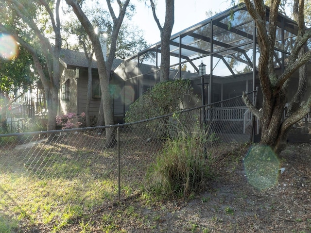 view of side of home featuring a lanai and fence