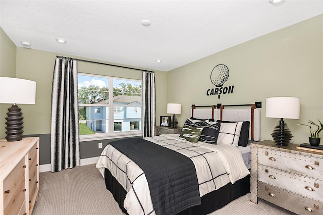 bedroom featuring light colored carpet and a textured ceiling