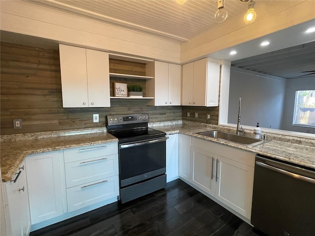 kitchen with stainless steel appliances, white cabinets, light stone counters, and sink