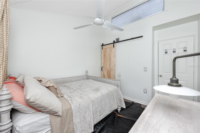 bedroom with ceiling fan and a barn door