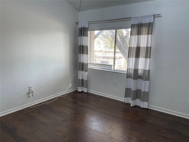 empty room with lofted ceiling and dark wood-type flooring