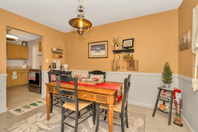 dining area with light carpet and a textured ceiling