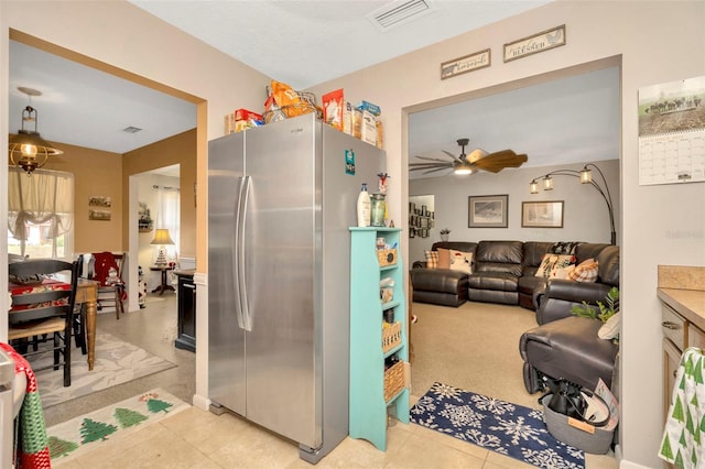 kitchen featuring stainless steel fridge, ceiling fan, and light carpet