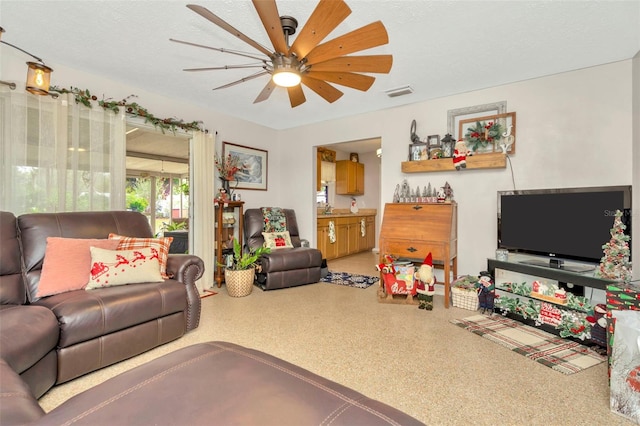 living room with ceiling fan and a textured ceiling