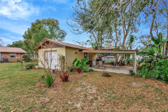 back of house with a yard, a garage, and a patio area