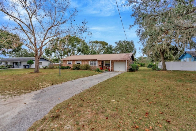 single story home featuring a garage and a front yard