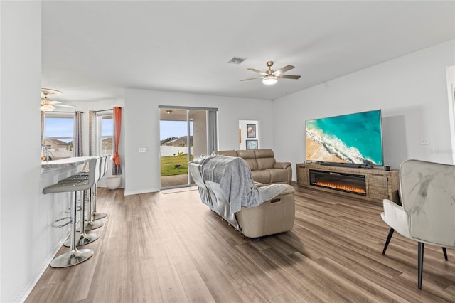 living room featuring hardwood / wood-style floors and ceiling fan