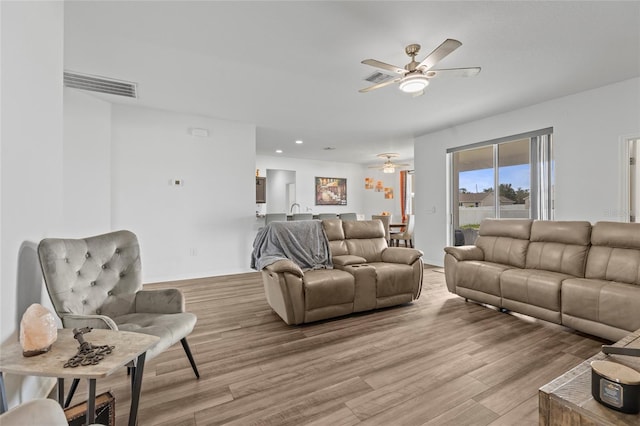 living room featuring ceiling fan and light hardwood / wood-style floors