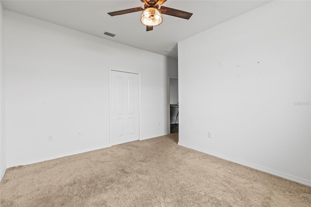 empty room featuring ceiling fan and carpet