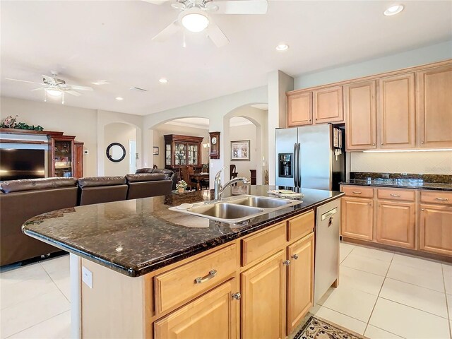 kitchen featuring a kitchen island with sink, sink, light tile patterned floors, light brown cabinetry, and stainless steel appliances