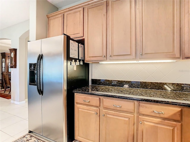 kitchen featuring decorative backsplash, stainless steel fridge, light tile patterned floors, and light brown cabinetry