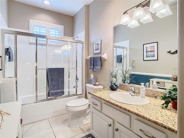 full bathroom featuring tile patterned flooring, vanity, toilet, and bath / shower combo with glass door