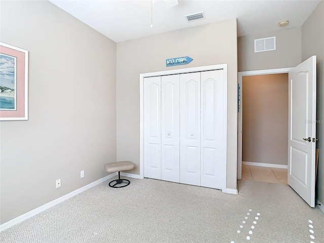 unfurnished bedroom with light carpet and a closet