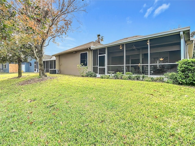 back of property featuring central AC, a sunroom, and a yard