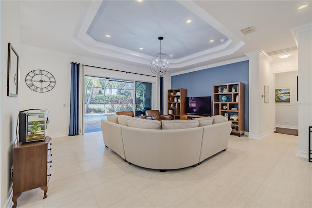 living room featuring a tray ceiling, light tile patterned floors, a notable chandelier, and ornamental molding