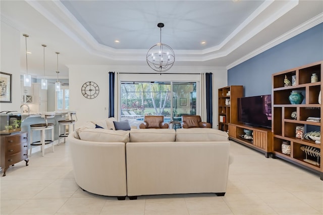 living room with an inviting chandelier, light tile patterned flooring, ornamental molding, and a tray ceiling