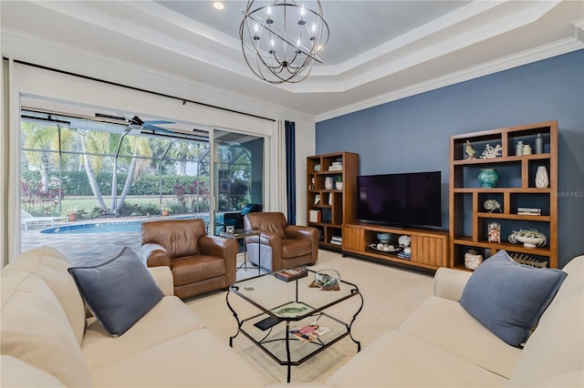 living room with ceiling fan with notable chandelier, a raised ceiling, and ornamental molding