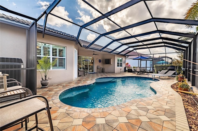 view of pool with a lanai, central AC, ceiling fan, and a patio