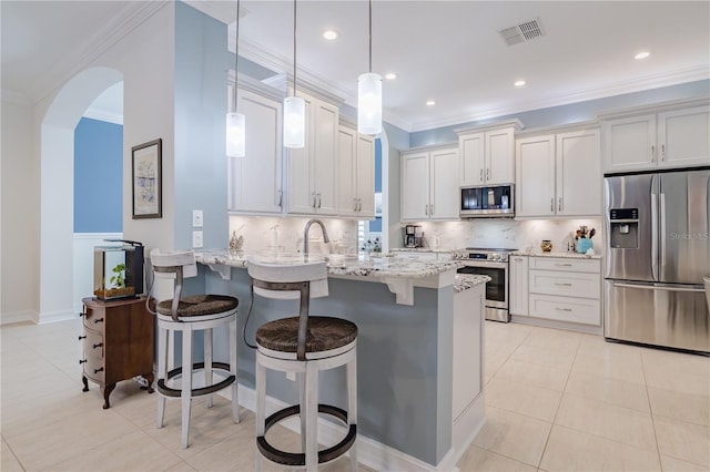 kitchen featuring light stone countertops, stainless steel appliances, pendant lighting, a kitchen bar, and decorative backsplash