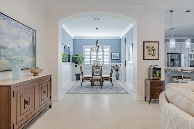 dining space featuring ornamental molding, light tile patterned floors, and a chandelier