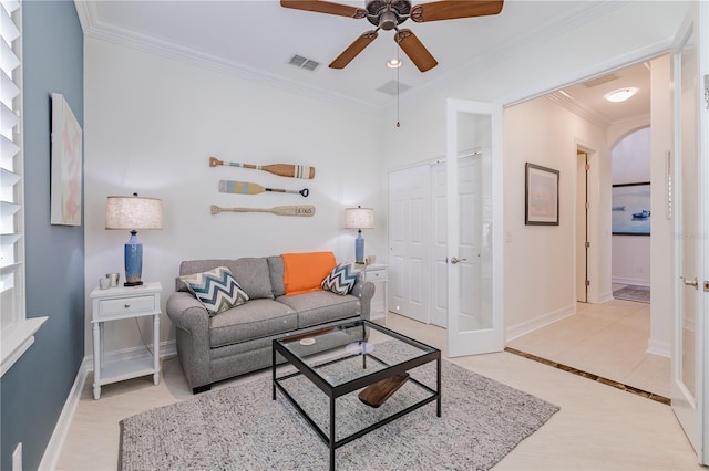 tiled living room featuring ceiling fan and crown molding