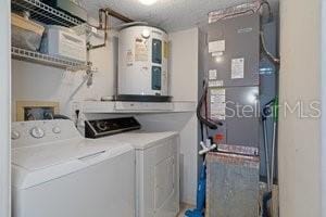 washroom with washer and clothes dryer and water heater