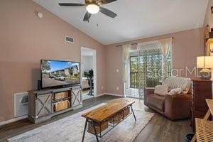 living room featuring hardwood / wood-style flooring, ceiling fan, and vaulted ceiling