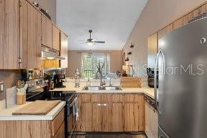 kitchen with stainless steel refrigerator, ceiling fan, sink, electric range oven, and kitchen peninsula