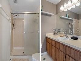 bathroom featuring tile patterned flooring, vanity, toilet, and walk in shower