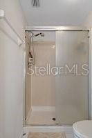 bathroom with an enclosed shower and toilet