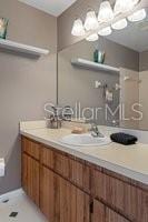 bathroom with tile patterned floors, vanity, and a chandelier