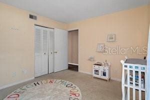 bedroom featuring light carpet and a closet